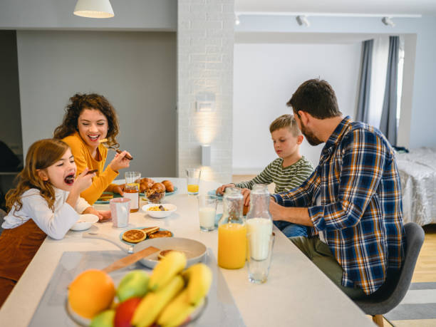 istock Young happy family communicating while having breakfast in the kitchen 1295763102