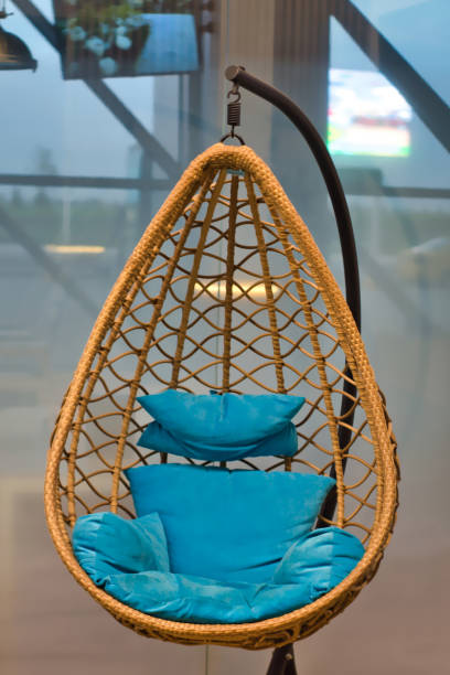 istock The hanging chair is egg braided. With blue pillows. View from the front. 1295763235