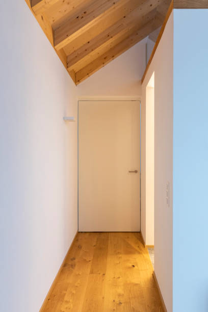 istock Front view hallway with white door and visible wooden beams. Nobody inside 1295763281