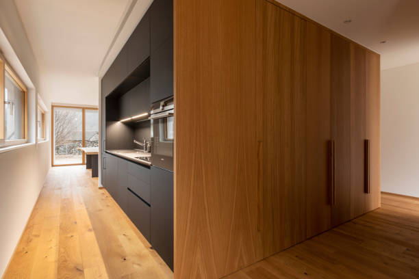 Modern design of Home Kitchen Interior made of wood materials. Wooden furniture in house. Dining room. Sink and fridge. Brown color. Window on background. Contemporary rustic and vintage old handmade
