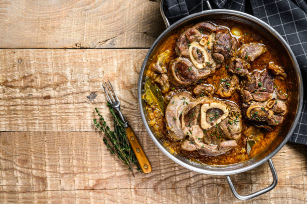 stinco di manzo in stufato osso buco, bistecca ossobuco italiana. sfondo di legno. vista dall'alto. spazio di copia - meat steak veal beef foto e immagini stock