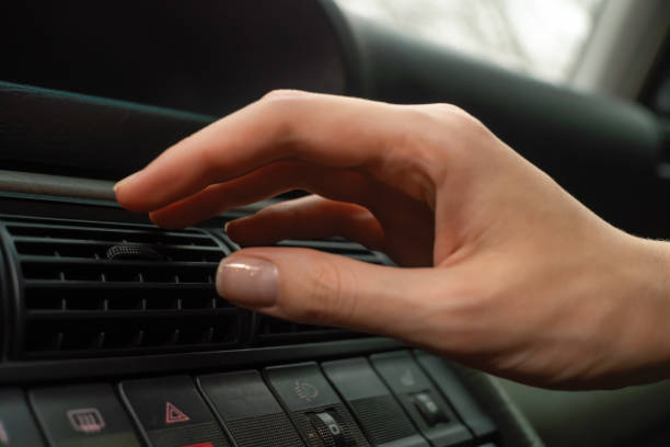 woman's hand on the ventilation grate of an air conditioner in a car close-up. climate control panel - car air conditioner vehicle interior driving imagens e fotografias de stock