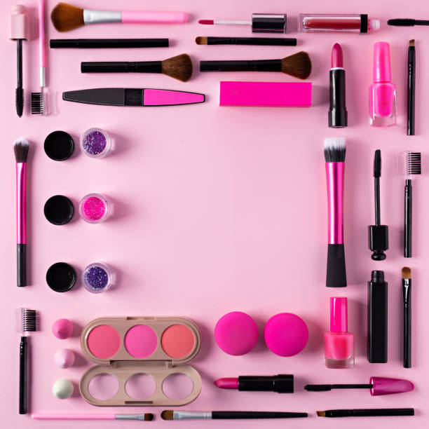 istock Make up frame border made with mascara, lipstick, brushes and eye shadow on pink background 1295765966