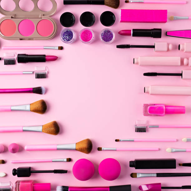 istock Make up frame border made with mascara, lipstick, brushes and eye shadow on pink background 1295765967