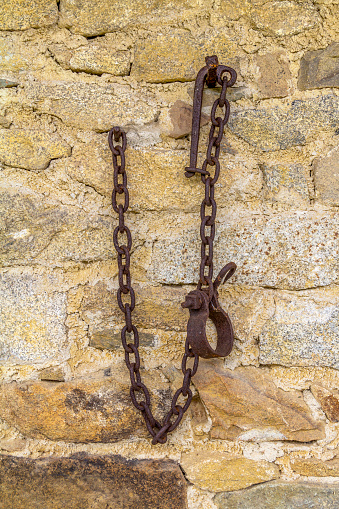 stone wall with fixed rusty rundown chains
