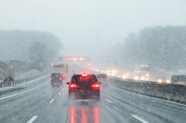 istock highway with cars in winter with snow fall 1295766791