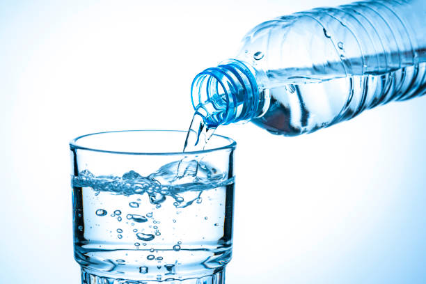 istock Pouring water from a plastic bottle to a drinking glass 1295766876