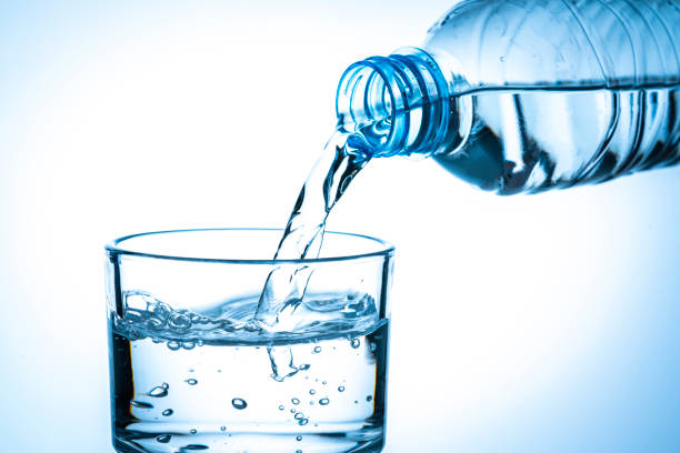 istock Pouring water from a plastic bottle to a drinking glass 1295766882