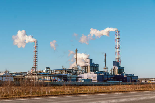 rohre mit riesigen rauchwolken in der fabrik gegen den blauen himmel an einem sonnigen tag, foto von der straße. konzept der ökologie, umweltverschmutzung - old station natural gas russia stock-fotos und bilder