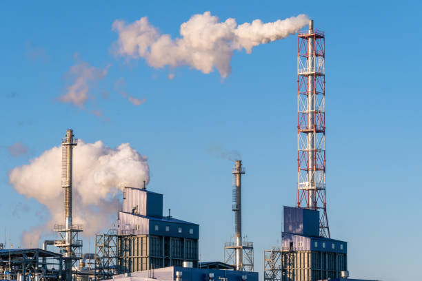 canos com enormes nuvens de fumaça na fábrica de perto contra o céu azul em um dia ensolarado. conceito de ecologia, poluição ambiental - old station natural gas russia - fotografias e filmes do acervo