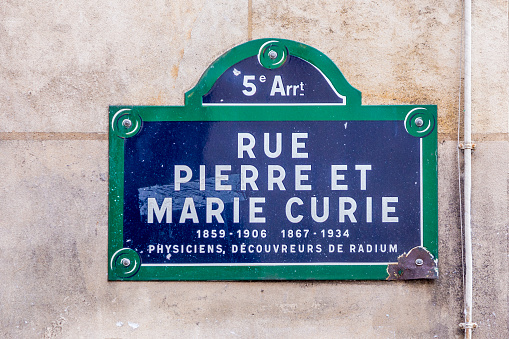 old street sign  Rue Pierre et Marie Curie - english: street Pierre and Marie Curie in the old historic part of Paris, France with text physicist, explorer of the element radium