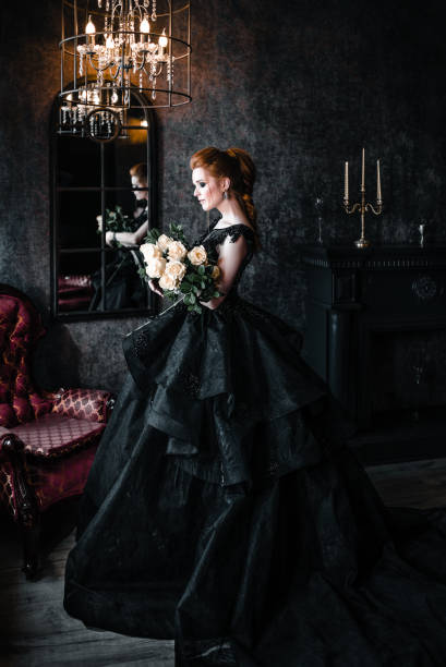 Attractive woman in black dress in medieval interior Attractive woman in black gothic dress. Indoor shoot vampire woman stock pictures, royalty-free photos & images