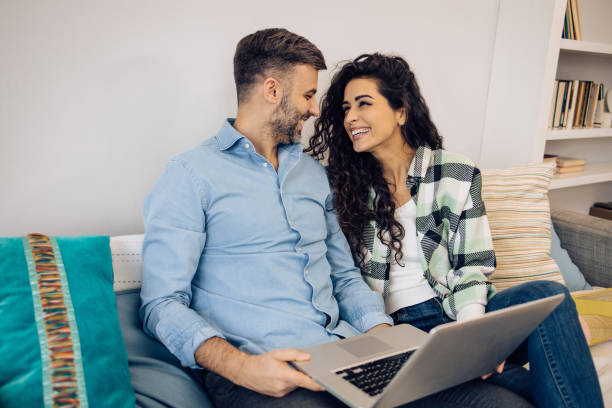 istock Couple relaxing on the sofa and surfing the net 1295768370