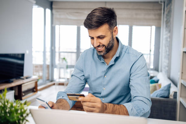 istock Happy man buying something online at his home office 1295768401