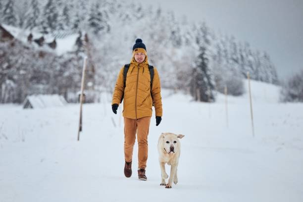 istock Front view of young man with dog in winter 1295770401