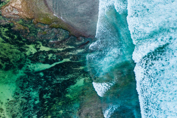Big ocean waves hitting a coral reef. View from above.