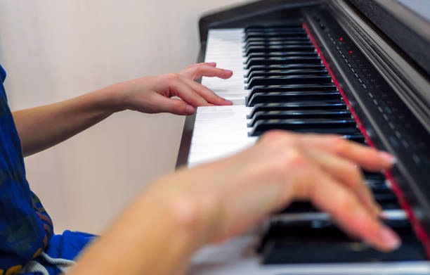 istock The hands of unknown a caucasian boy who is playing electronic piano. 1295770954