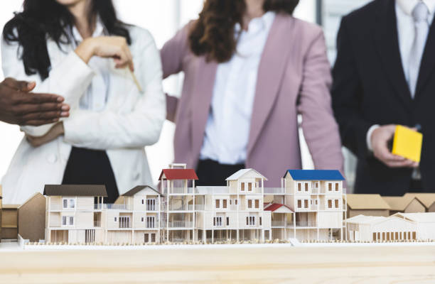 istock Diversity architect and businesspeople group discussion drawing house design with 3D model simulation 1295771861