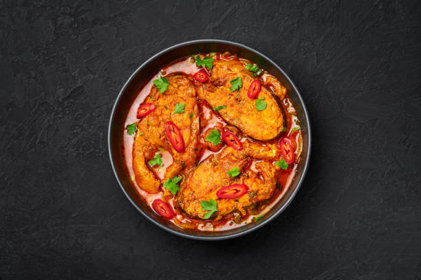 macher jhol dalam mangkuk hitam di atas meja batu tulis gelap. masakan india bengali fish curry. makanan dan makanan asia. tampilan atas - ikan potret stok, foto, & gambar bebas royalti