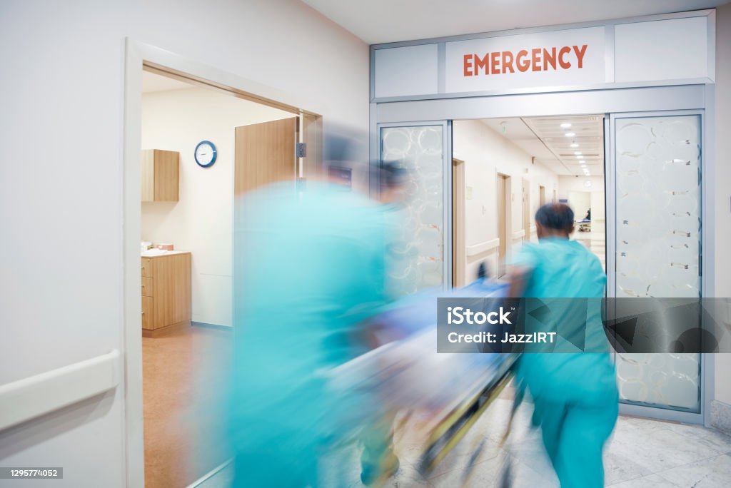 Doctor wheeling patient Emergency Room Stock Photo