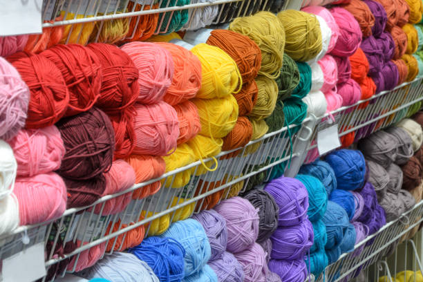 istock Counter in shop for knitting and needlework with coils colored wool yarn. Different bright colors threads 1295775220
