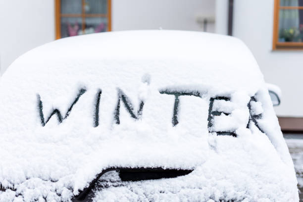 istock A snow-covered car with the German text Winter on the windshield 1295777291