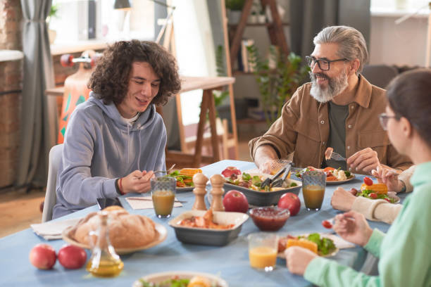 istock Family sitting at dining table 1295778557