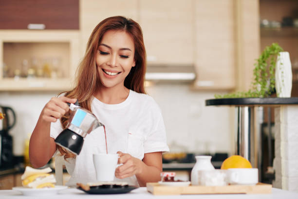 istock Woman pouring herself coffee 1295779614