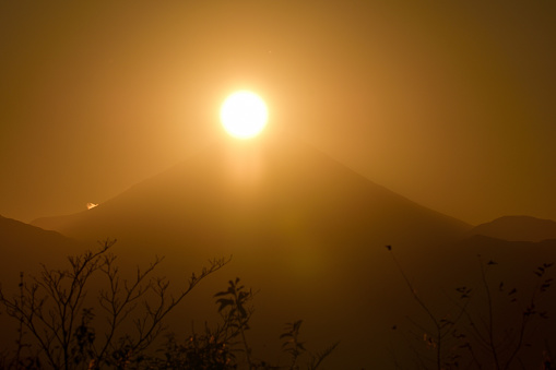 The sun is setting in on the peak of Mt. Fuji on December 21, 2020, the day of the winter solstice, which was taken from the summit of Mt. Takao, located in the suburbs of Tokyo.\nMt. Fuji is designated as UNESCO World Heritage site.