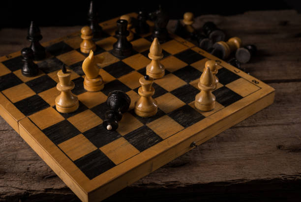 istock Wooden Chess Pieces on the old Chessboard against dark background. 1295780652