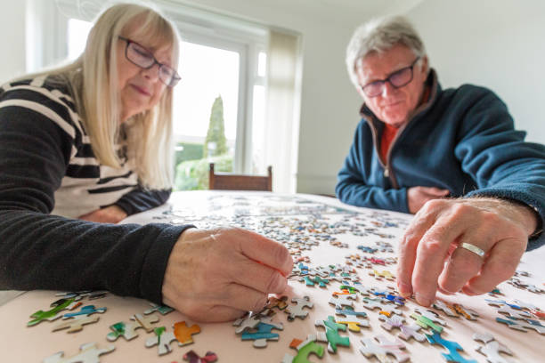 istock Senior retired couple doing jigsaw puzzle together at home 1295780711