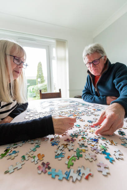 istock Senior retired couple doing jigsaw puzzle together at home 1295780729