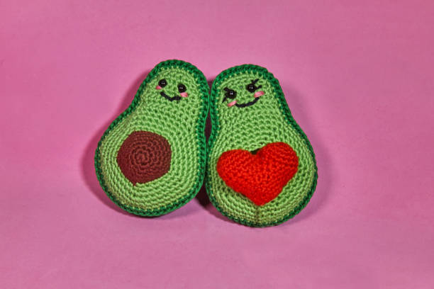 симпатичные крючком авокадо игрушка, на розовом фоне ручной работы вязаные игрушки. - yarn ball стоковые фото и изображения