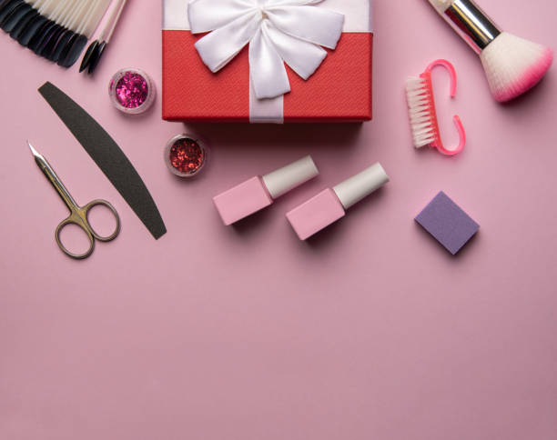 istock Set of manicure tools and accessories with red gift box on a pink background. Hardware manicure,Flat lay. 1295784313