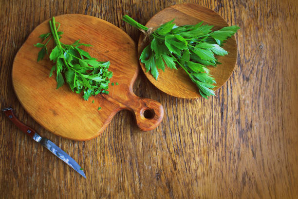 Lovage herb on cutting board. Woden background Lovage herb on cutting board. Woden background . lovage stock pictures, royalty-free photos & images