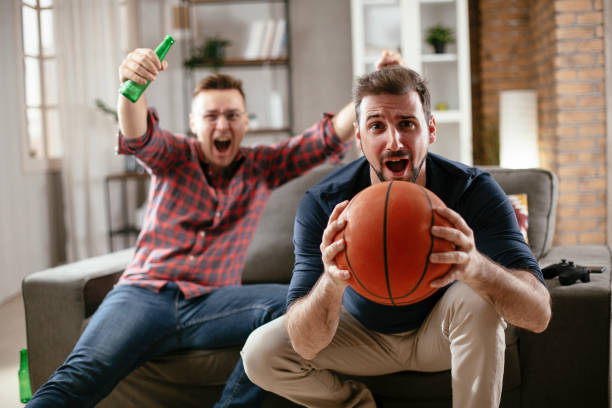 istock Men drinking beer and watching sports game on tv. 1295785906