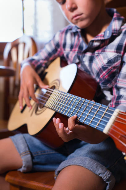 istock Boy playing, practicing acoustic guitar at home 1295787315