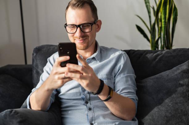 istock A guy with a smartphone sits on the couch 1295789037