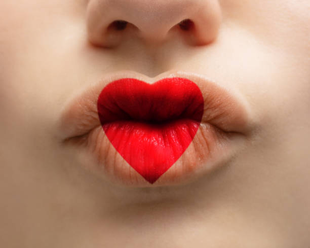 istock Red heart on female lips 1295789976