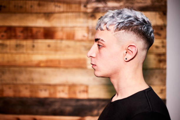 verticale de vue de côté du jeune homme latin avec la coiffure sur le fond en bois. - shaved head photos et images de collection