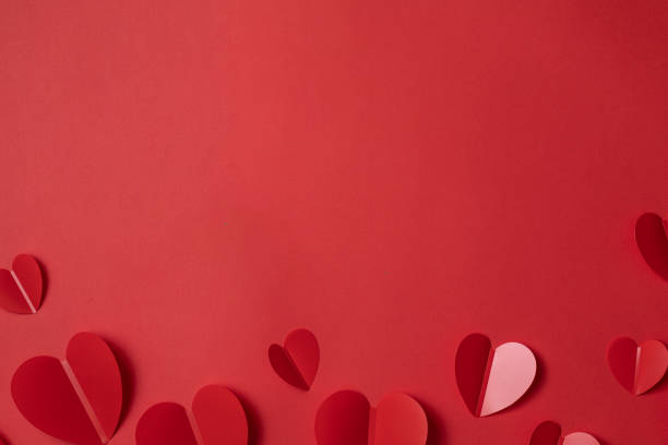 istock Valentine's day background with heart shape decorations and ribbons. View from above. Flat lay composition on red 1295790164