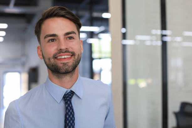 istock Young handsome businessman smiling in an office environment 1295790790