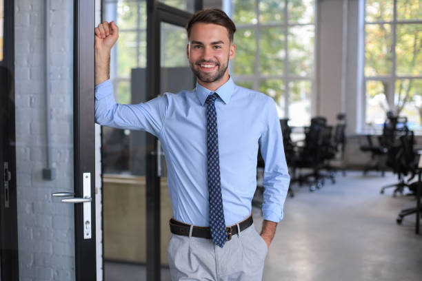 istock Young handsome businessman smiling in an office environment 1295791605