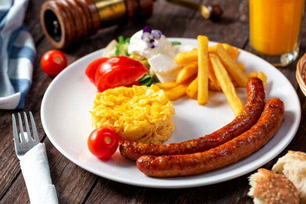 istock Breakfast concept with scrambled eggs and fried sausages 1295793629