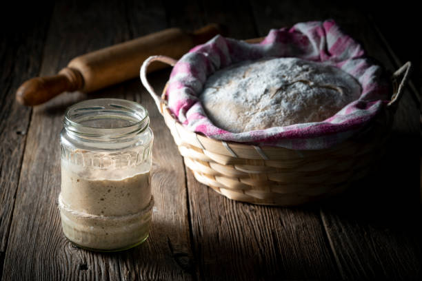 Sourdough preparing real bread dough homemade bakery in moody wooden table Sourdough glass preparing real bread dough homemade bakery in moody wooden table low key dark background yeast starter stock pictures, royalty-free photos & images