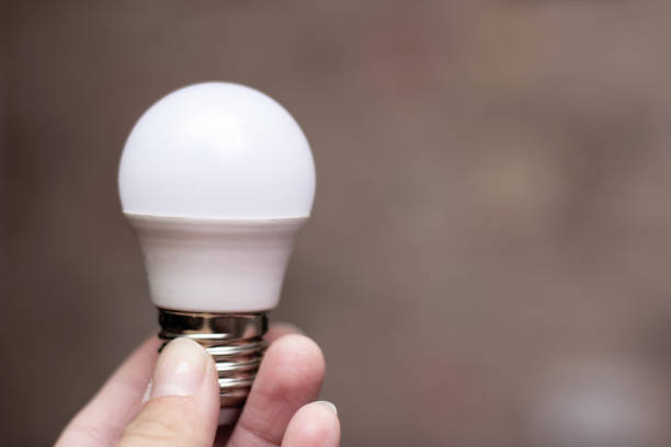istock White light bulb in hand close up 1295794188