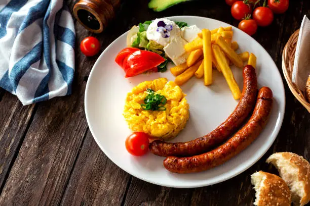 Photo of Highly nutritive breakfast dish with scrambled eggs and sausage