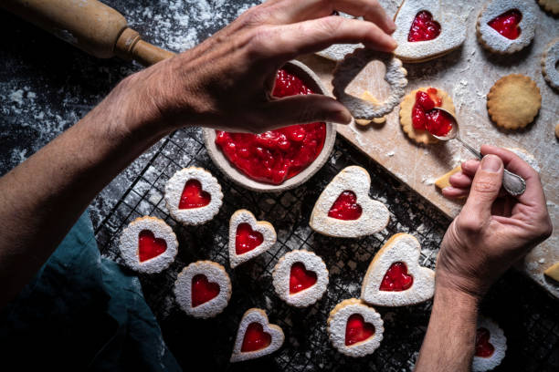 istock Linzer cookies preparation man hands put strawberry jam with spoon 1295795607