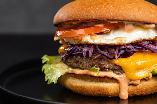 Cheese burger with bacon on black dark background