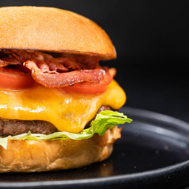 istock Cheese burger with bacon on black dark background 1295796145